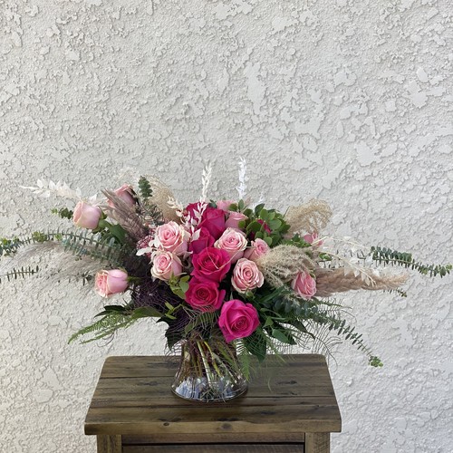 Pink and hot pink roses with pampas grass and fern in a glass vase by Raleigh floral studio