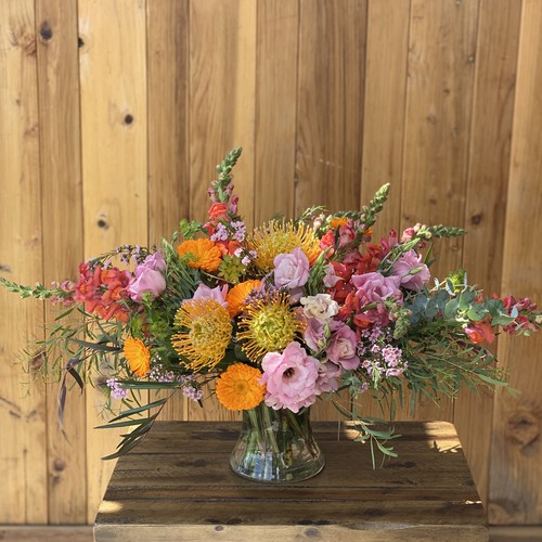Vibrant protea lisianthus and snapdragons in a glass vase by Raleigh floral studio
