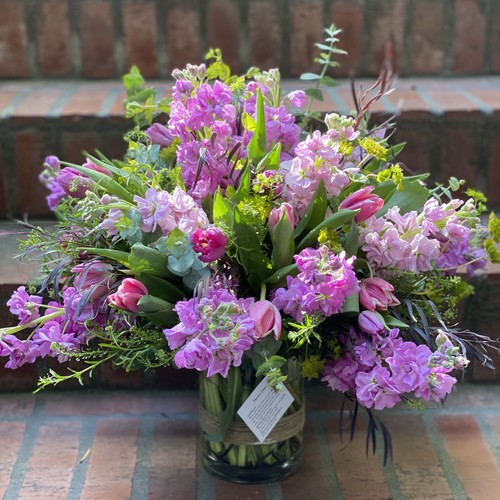 Lavender stock and pink tulips with greenery in a glass vase by Raleigh floral studio